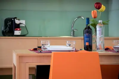 a table with an orange chair and a bottle of wine at Vitorno Residence in San Vito lo Capo