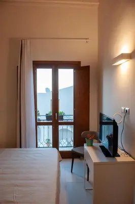 a hotel room with a bed and a desk and a window at Baglio La Riserva in Scopello