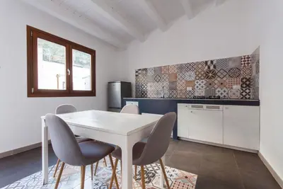 a kitchen with a white table and chairs at Casa Leonardo e Romeo in Castellammare del Golfo