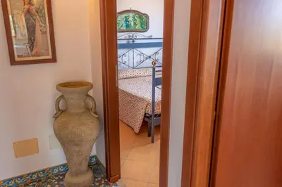 a hallway with a vase next to a bedroom at Villa Verde con vista sul mare in San Vito lo Capo