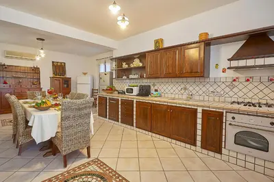a large kitchen with a table and a counter top at Villa Sansone in Altavilla Milicia