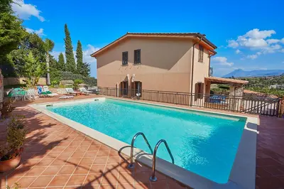 a large swimming pool in front of a house at Villa Sansone in Altavilla Milicia