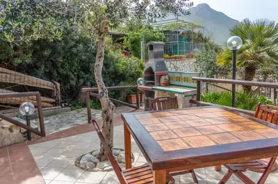 a table and chairs on a patio with a stove at Baglio cracchiolo da tuzzo Villa Ulivo in San Vito lo Capo