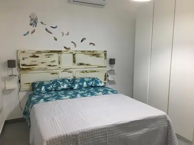 a bedroom with a bed with a wooden headboard at Casa Nicuzza in Palermo