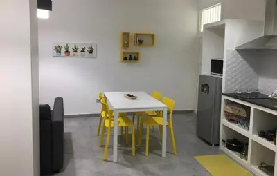a small kitchen with a table and yellow chairs at Casa Nicuzza in Palermo