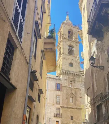 a tall building with a clock tower on a street at Casa Nicuzza in Palermo