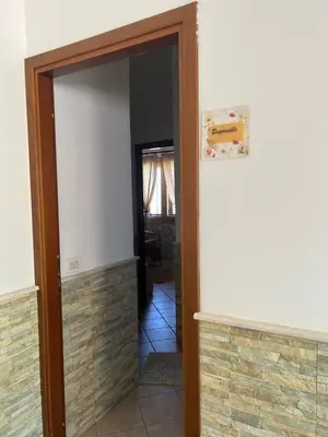an open door into a hallway with a brick wall at Baglio Cracchiolo da Tuzzo - Casa Bouganville in San Vito lo Capo