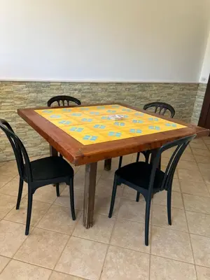 a wooden table with four chairs and a table with at Baglio Cracchiolo da Tuzzo - Casa Bouganville in San Vito lo Capo