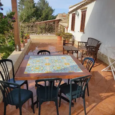 a wooden table and chairs on a patio at Baglio Cracchiolo da Tuzzo - Casa Carrubbo in San Vito lo Capo