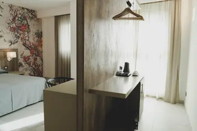 a bedroom with a bed and a desk in a room at Hotel Pontemare in Palermo