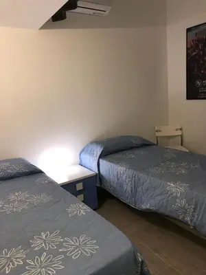 a room with two beds and a table with a lamp at Casa Tatiana in Palermo