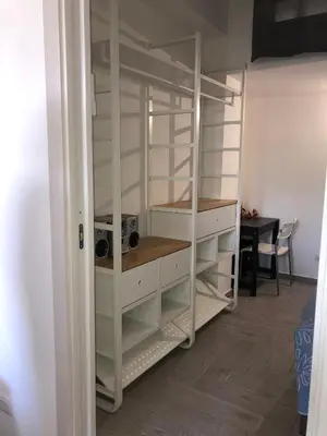 a closet with white shelves and a table at Casa Tatiana in Palermo