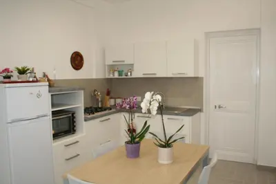 a kitchen with a wooden table with flowers on it at Casa Tatiana in Palermo