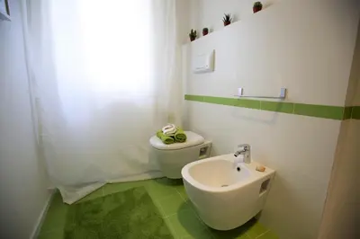a bathroom with a white toilet and a sink at GIULIA E CHIARA LUXURY APARTMENT in Castellammare del Golfo