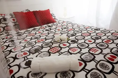 a bedroom with a bed with a black and white bedspread at GIULIA E CHIARA LUXURY APARTMENT in Castellammare del Golfo