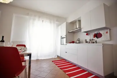 a kitchen with white cabinets and a red and white rug at GIULIA E CHIARA LUXURY APARTMENT in Castellammare del Golfo