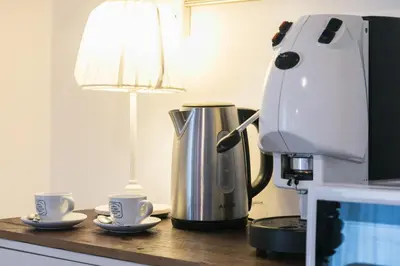 a coffee machine sitting on a counter next to two cups at Corte del Merlo in Palermo