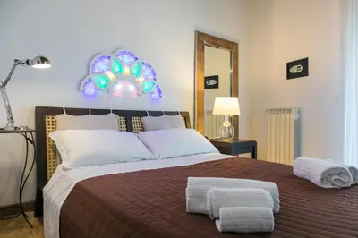 a bedroom with a large bed with two towels on it at Corte del Merlo in Palermo