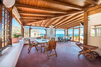 a dining room with a table and chairs and the ocean at Casa con Terrazza sul Mare all'Addaura by Wonderful Italy in Palermo