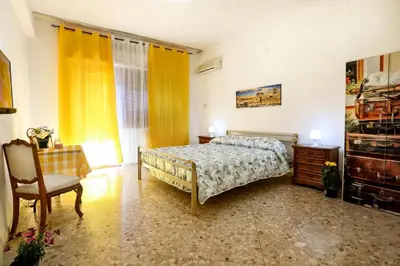 a bedroom with a bed and a chair at A Casa di Fra' in Palermo