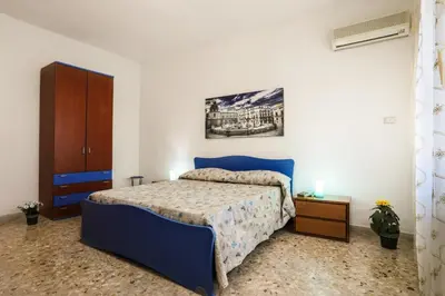 a bedroom with a blue bed and a cabinet at A Casa di Fra' in Palermo