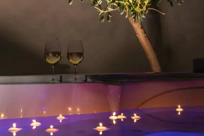 two glasses of wine sitting on a table with candles at SICULI HORTIS SEA HOME - Villa - Jacuzzi - Air Conditioning - Free Parking - Video Surveillance & Alarm System in Altavilla Milicia
