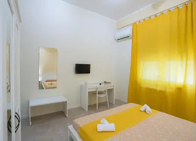a bedroom with two beds and a yellow curtain at Le Stanze Dell'Emiro in Palermo