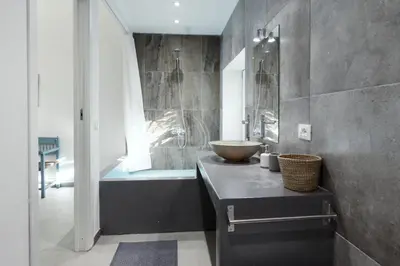 a white bedroom with two beds and a kitchen at Naturarte Guesthouse in Terrasini