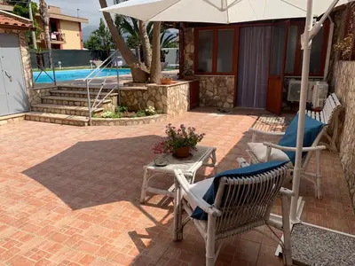 a patio with a table and chairs and an umbrella at Casa vacanze Villa Grace in Villagrazia