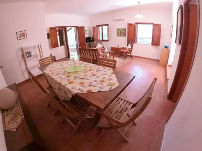 a dining table and chairs in a living room at Villa Marilù in Castellammare del Golfo