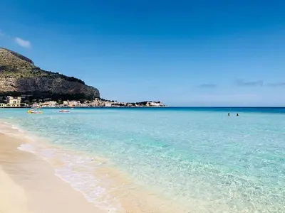 a beach with people swimming in the water at Teatro Massimo Apartment- SELF CHECK-IN in Palermo