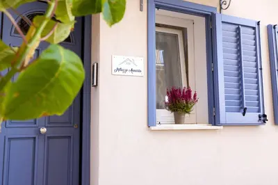 a window with a blue door and a potted plant at Appartamenti centro storico Milazzo Annarita in Castellammare del Golfo