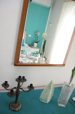 a mirror on a wall with a plant in front of it at APPARTAMENTO L'AIRONE in Balestrate