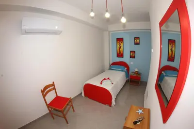 a bedroom with a bed and a chair and a table at APPARTAMENTO L'AIRONE in Balestrate