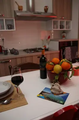 a table with a bowl of fruit and a glass of wine at APPARTAMENTO L'AIRONE in Balestrate