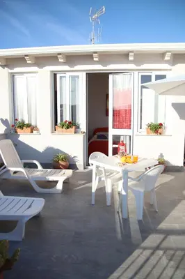 a patio with a white table and chairs at APPARTAMENTO L'AIRONE in Balestrate