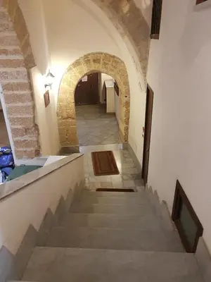 a hallway with a staircase in a building with an arch at La casetta di Sara in Palermo
