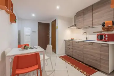 a kitchen with a table and chairs and a microwave at La casetta di Sara in Palermo