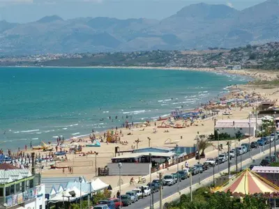a beach with a lot of people and the ocean at CASE VACANZE NONNA NICK in Castellammare del Golfo