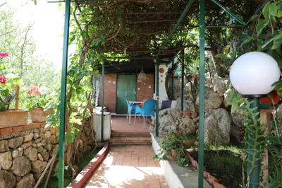 a patio with a table and chairs in a garden at Casa Elvira in Terrasini