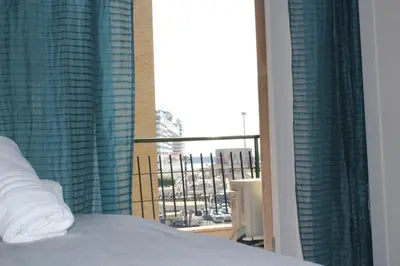 a bedroom with a bed and a window with a view at LA FINESTRA SUL PORTO in Palermo