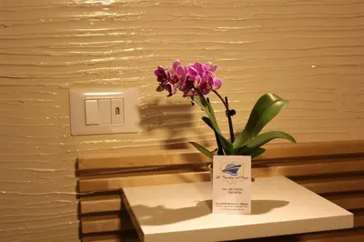 a vase with a purple flower sitting on a table at LA FINESTRA SUL PORTO in Palermo