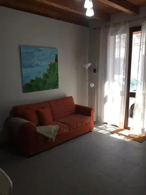 an orange couch in a living room with a window at Terra e Mare in Capaci