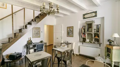 a room with tables and chairs and a staircase at Addimora Boutique Suites in Palermo