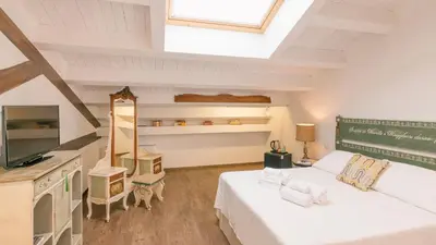 a attic bedroom with a bed and a television at Addimora Boutique Suites in Palermo