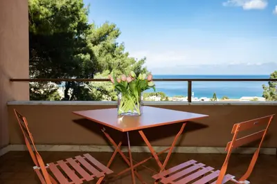 a table with a vase of flowers on a balcony at Villa nel verde sul mare, Mondello, Palermo in Palermo