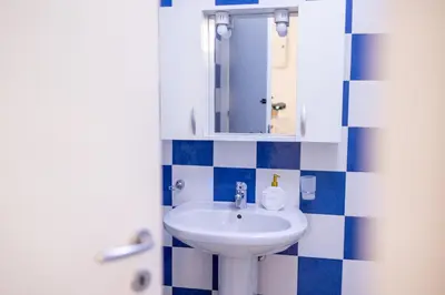 a bathroom with a white sink and blue and white tiles at Zangara Flat in Cinisi