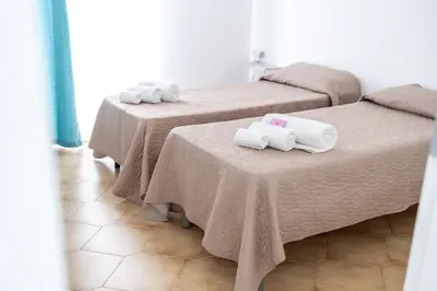 two beds with towels on them in a room at Zangara Flat in Cinisi