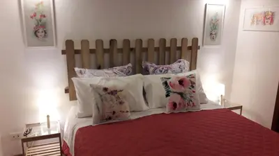 a bedroom with a bed with a red comforter and pillows at Casa Annuccia ai Quattro Canti di Città in Palermo