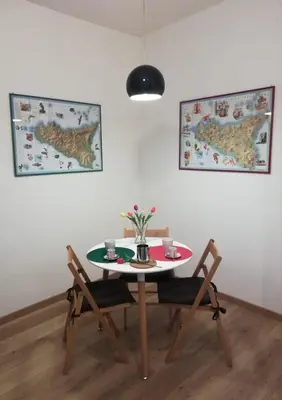 a table with two chairs and a table with flowers on it at Casa Annuccia ai Quattro Canti di Città in Palermo